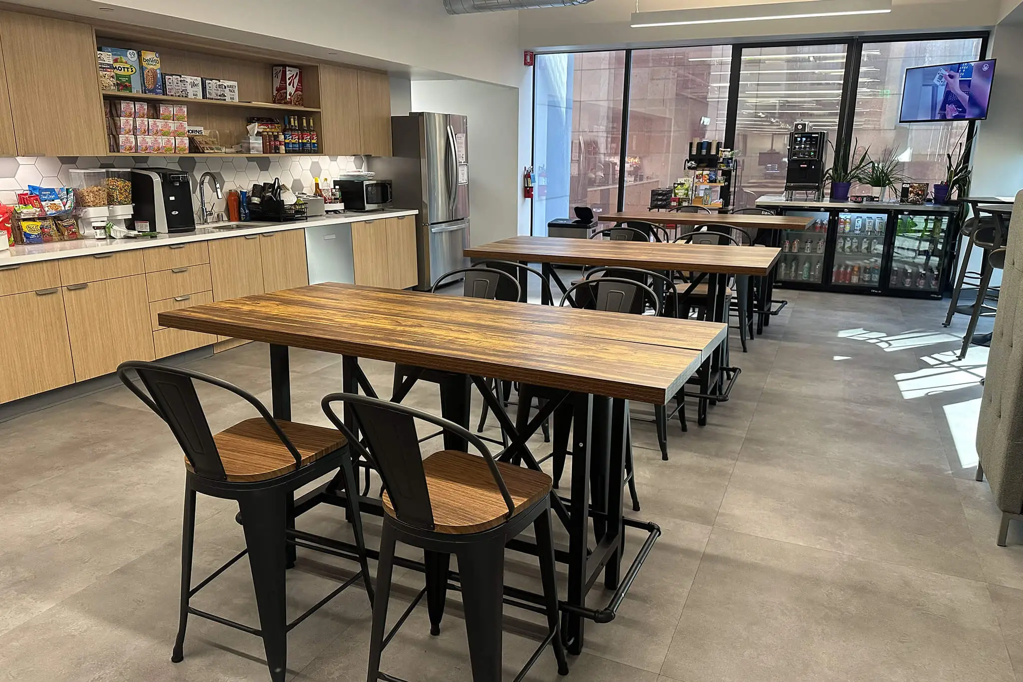 Open kitchen area in YuJa's office, equipped with tables and chairs for team gatherings and meals.