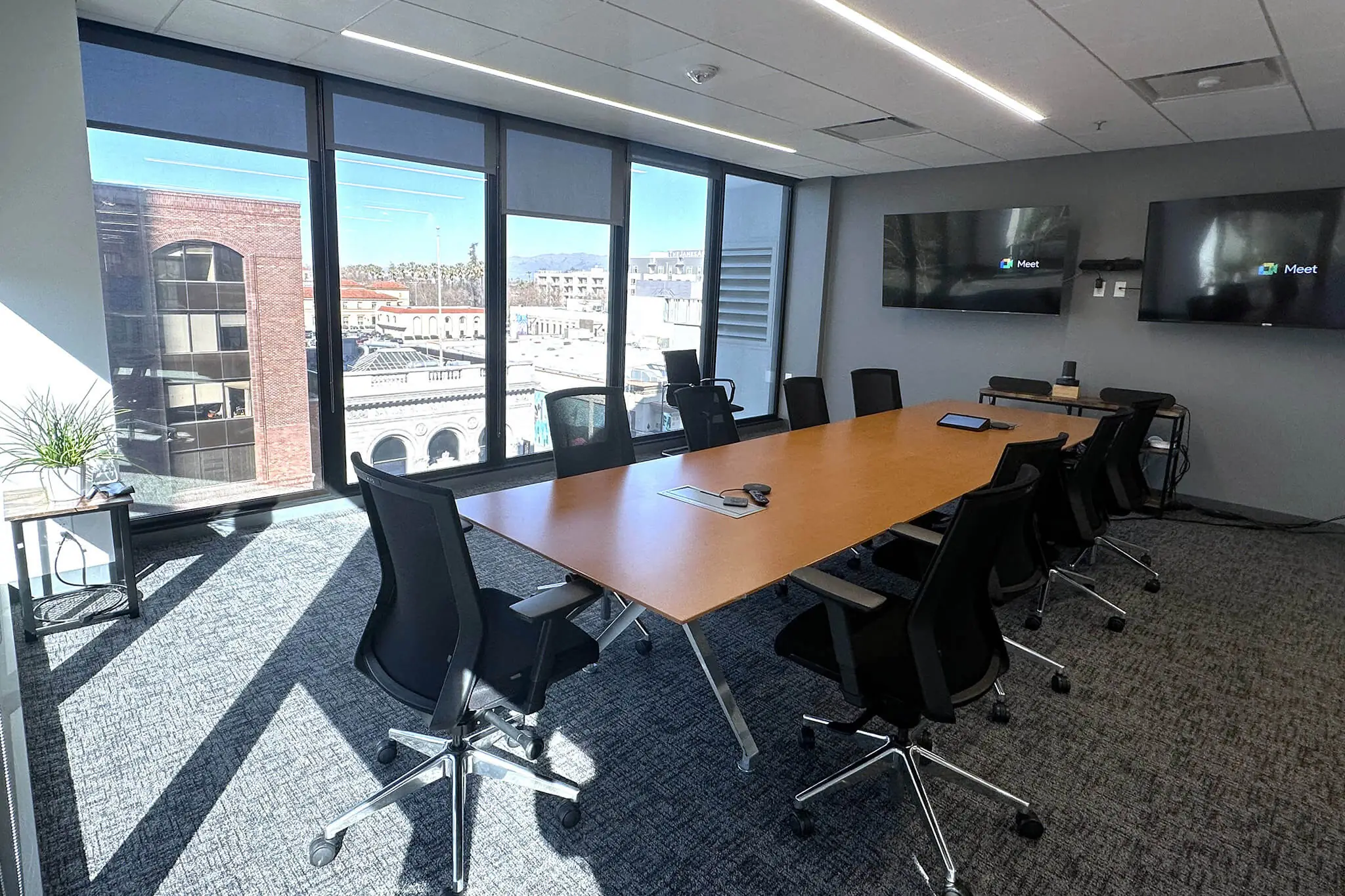 A spacious conference room in YuJa's Office featuring a large table surrounded by comfortable chairs.