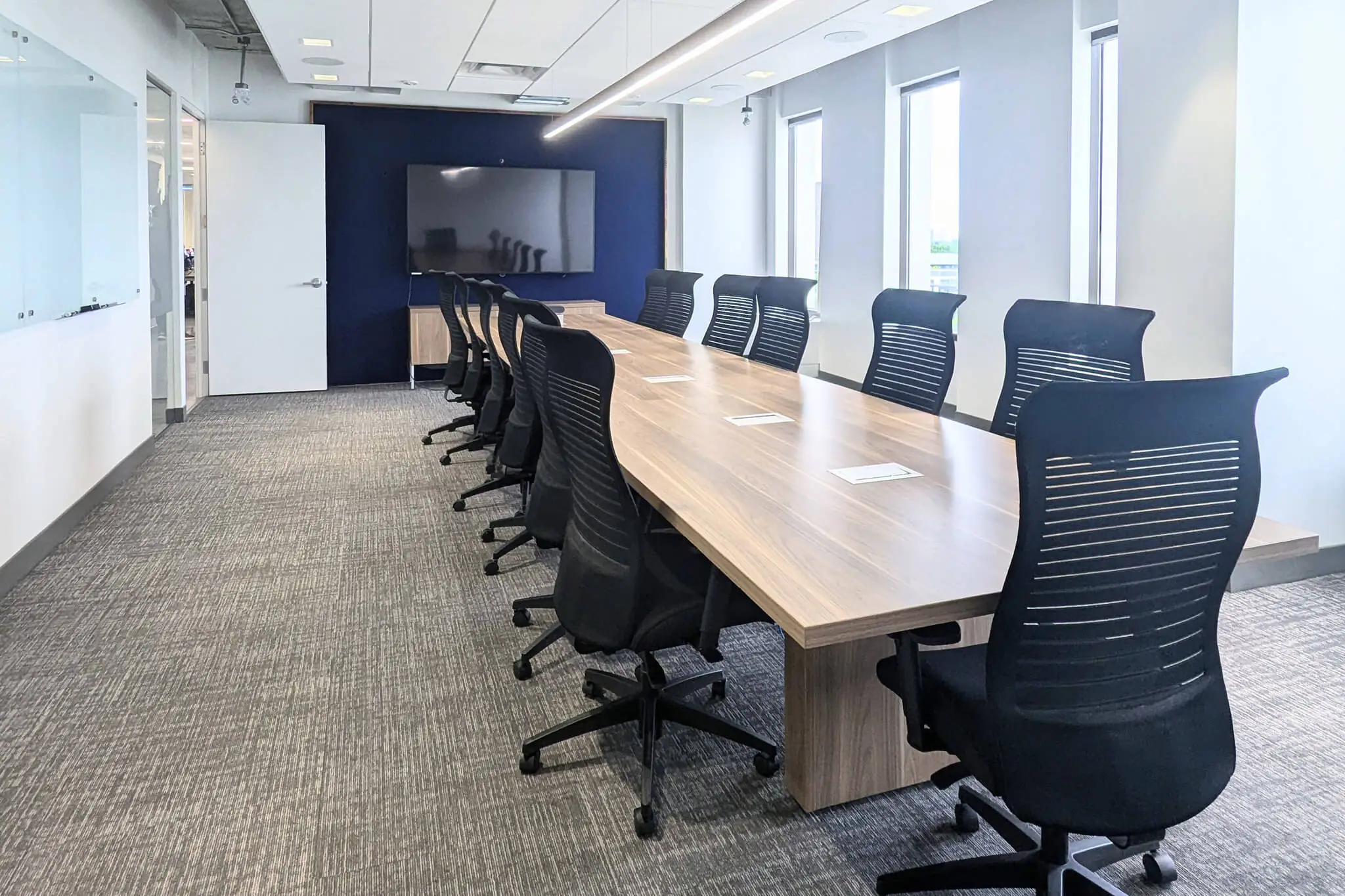 A conference room in YuJa's Office featuring a long table surrounded by chairs, ready for meetings and discussions.