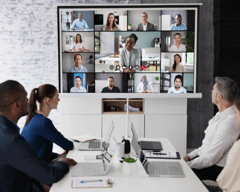 A group of people looking at a presenter on a screen.